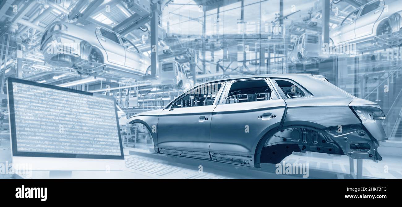 Production in the automotive industry with assembly lines, car bodies and screen with program code Stock Photo