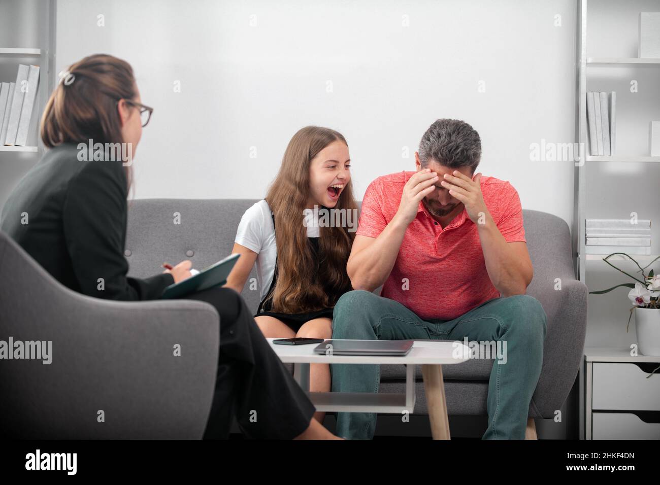 Family psychologist. Psychotherapy with father and and daughter tenager. Bad parents. Stock Photo