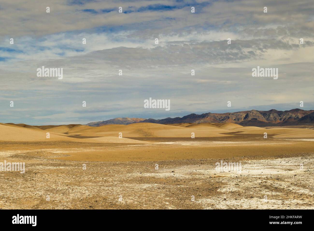 Abstract landscape of dunes and dark mountains in the desert and salt ...