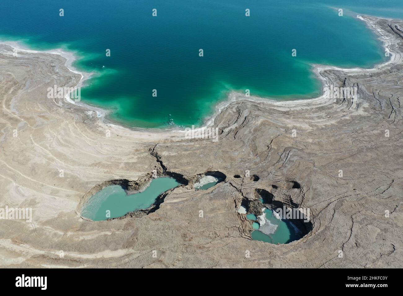 Dead Sea. 3rd Feb, 2022. Aerial photo taken on Feb. 3, 2022 shows sinkholes on the shore of the Dead Sea near Ein Gedi beach, Israel. As the Dead Sea is shrinking and its water levels decreasing, hundreds of sinkholes are devouring land where the shoreline once stood. Credit: Gil Cohen Magen/Xinhua/Alamy Live News Stock Photo