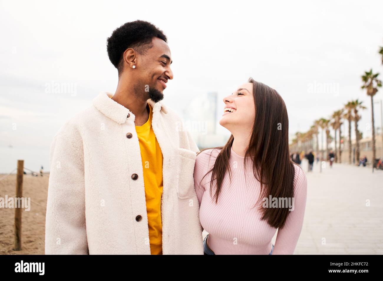 Multiracial young couple in love having fun together outdoors in the beach of the city. Stock Photo