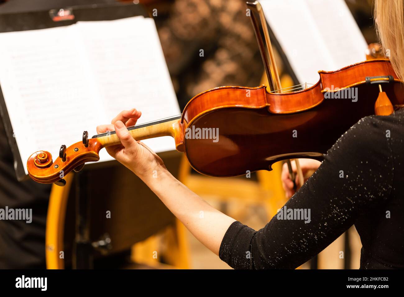 Symphony orchestra on stage, hands playing violin Stock Photo