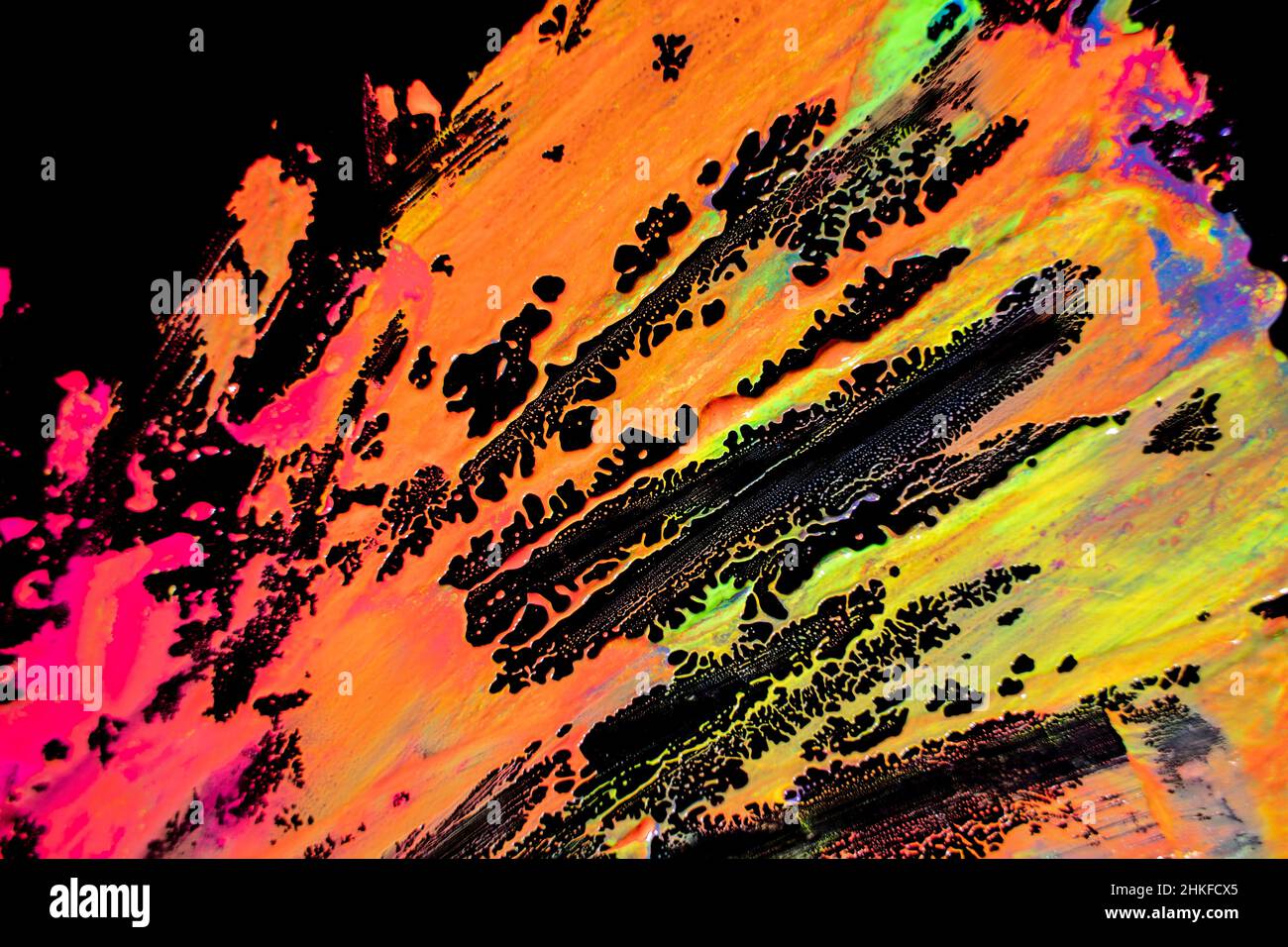 Abstract vibrant multi-color wet paint drops and splotch on black background. Bright orange and pink neon colors. Street art isolated Stock Photo