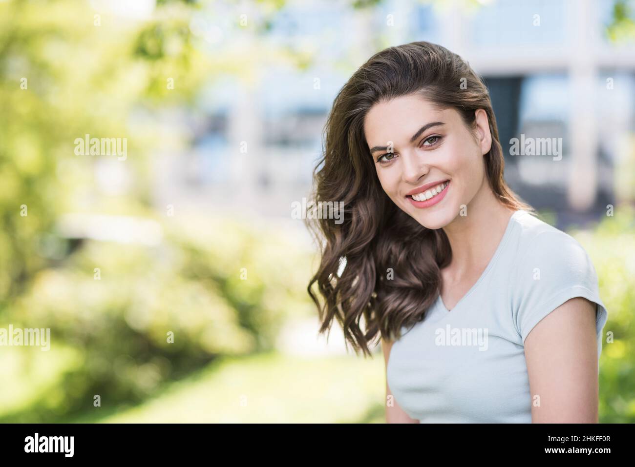 Beautiful happy young woman closeup portrait. Pretty model girl with perfect fresh clean skin smiling outdoors, Stock Photo