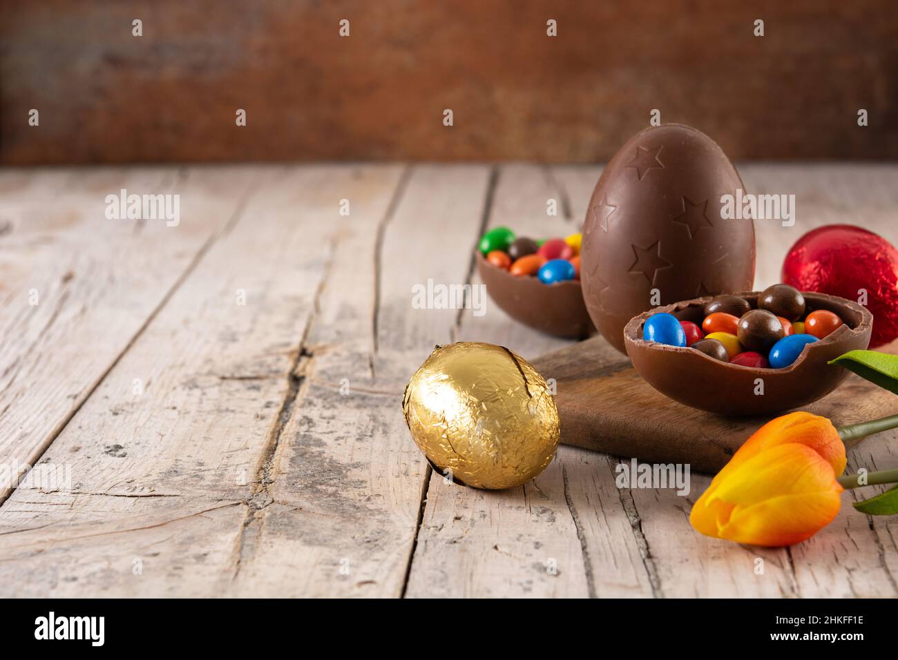 Colorful chocolate Easter eggs on wooden table Stock Photo