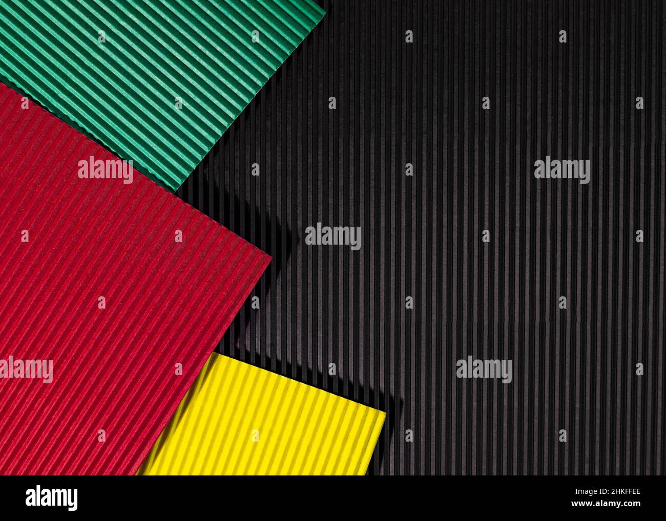 February Black History Month. Abstract corrugated paper geometric black, red, yellow, green background. Copy space, place for your text. Stock Photo