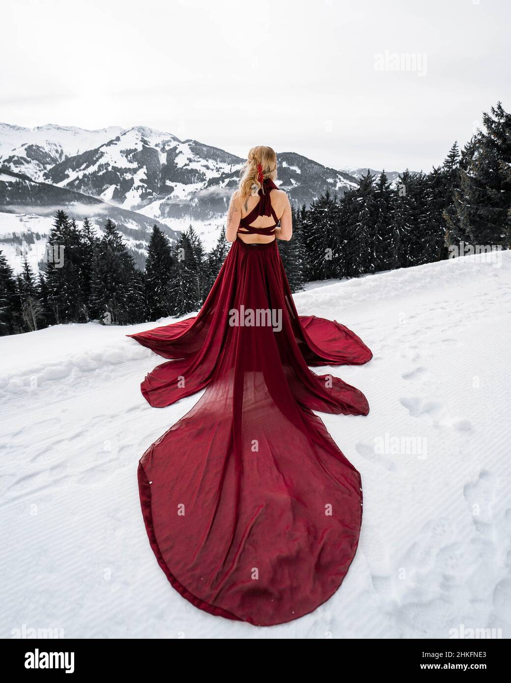 Young Land in red dress in the austrian winter landscape in the mountains  with new fashion and lifestyle Stock Photo - Alamy