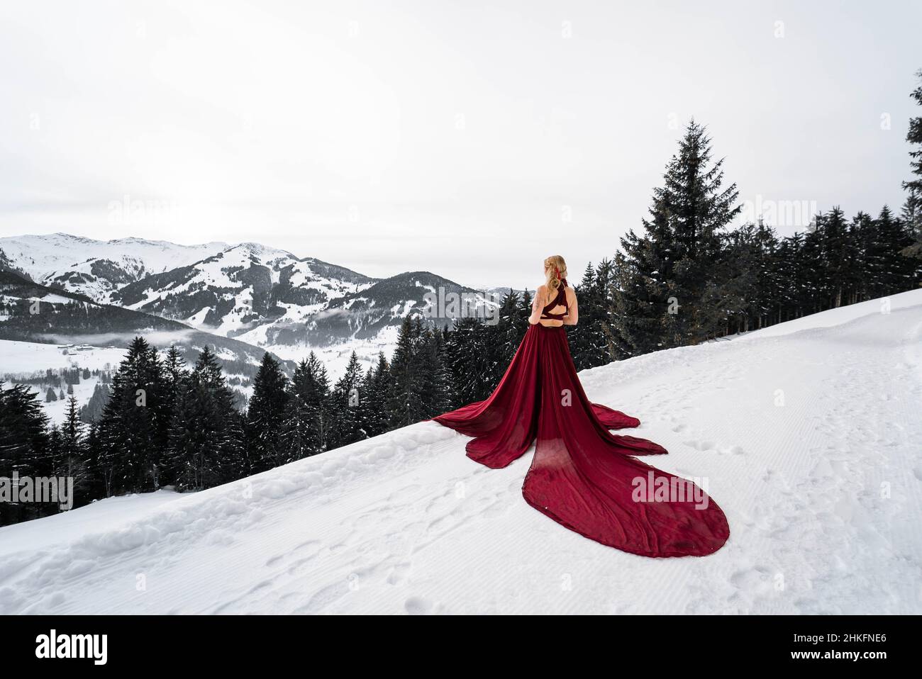 Young Land in red dress in the austrian winter landscape in the mountains with new fashion and lifestyle Stock Photo Alamy