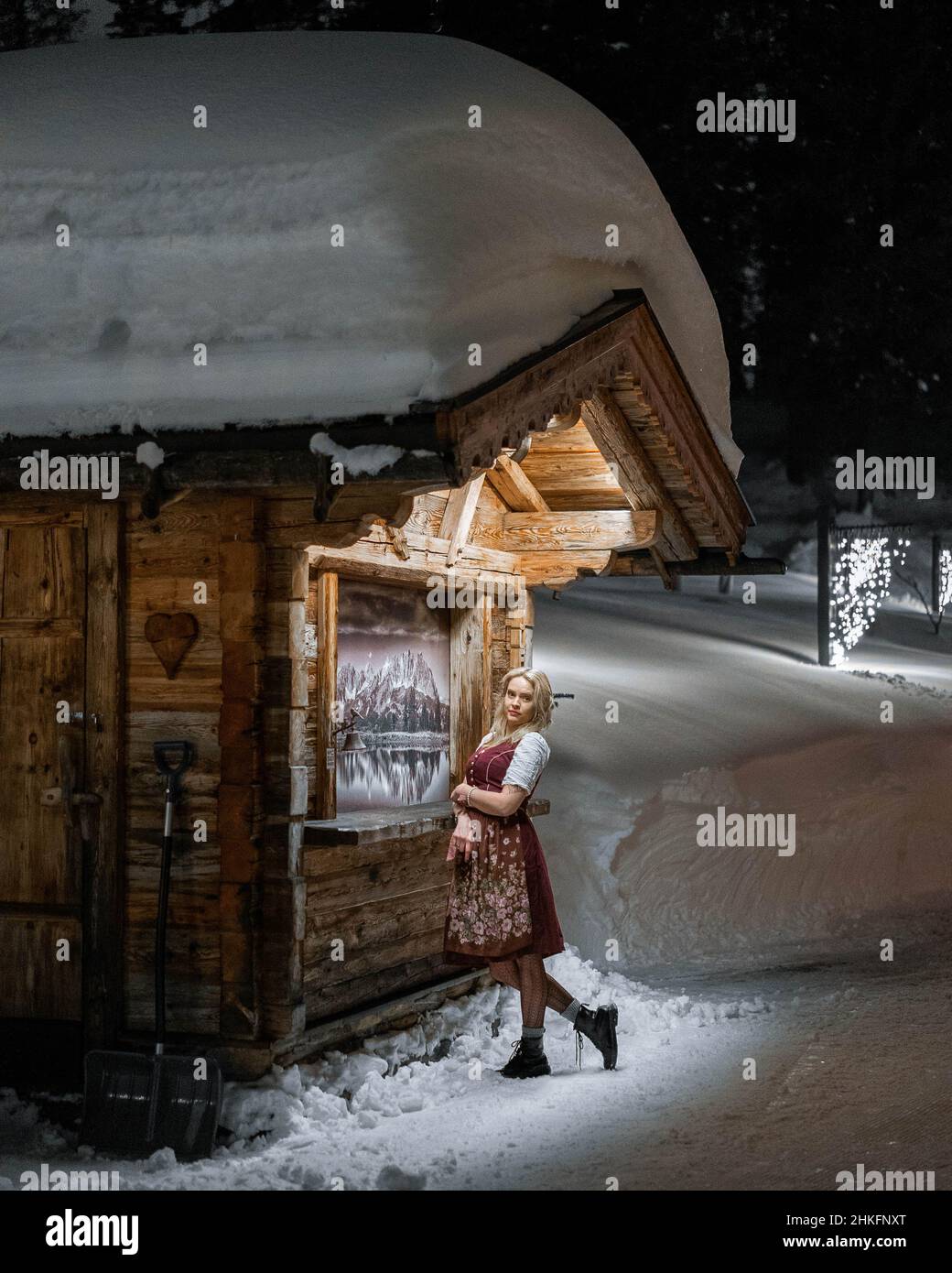 Young Land in red dress in the austrian winter landscape in the mountains with new fashion and lifestyle. Stock Photo