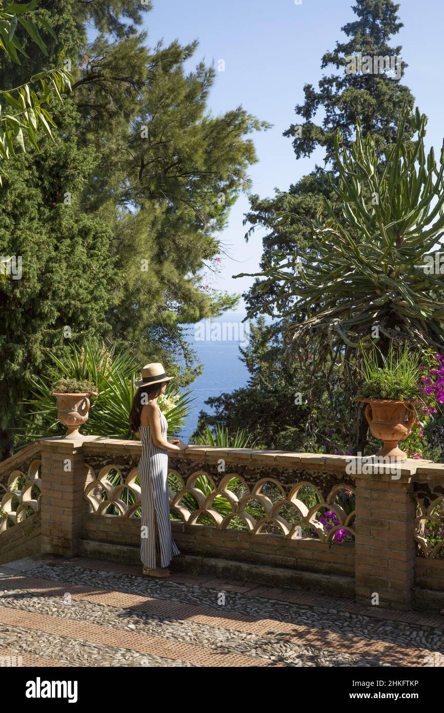 Italy, Sicily, Taormina, young woman wearing a hat in front of a belvedere on the Ionian Sea in the gardens of the communal villa, former property of the English Lady Florence Trevelyan Stock Photo