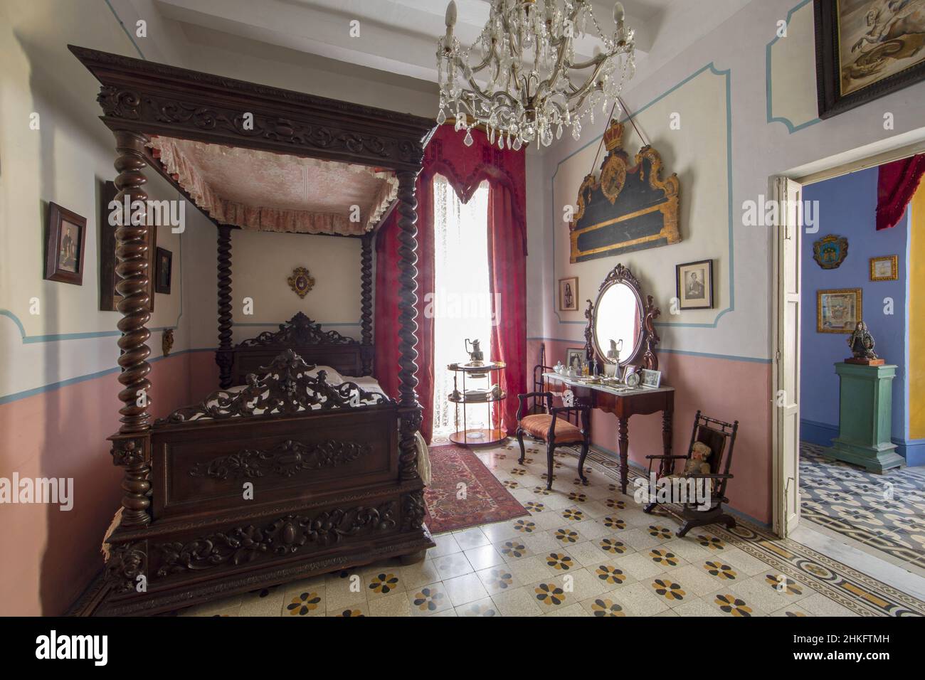 Malta, Valletta, bedroom of the Casa Rocca Piccola, a 16th century palace which houses a private museum and a bed and breakfast, decorated with a four-poster bed in woodwork, a crystal chandelier and a dining table toilet with mirror Stock Photo