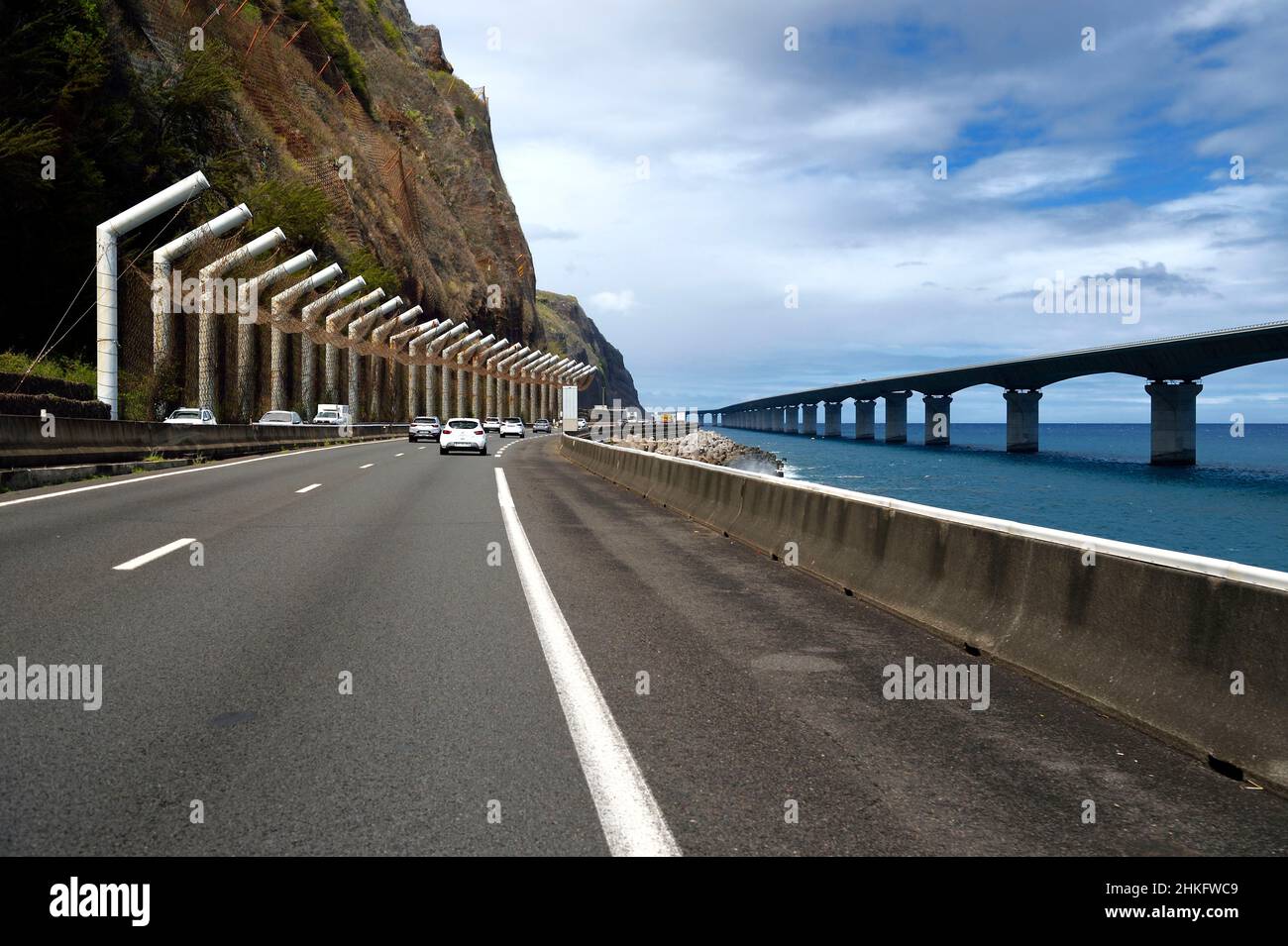 France, Reunion island (French overseas department), La Possession, the old national road still under the threat of rockfall and the New Coastal Route on the right ( Nouvelle Route du Littoral - NRL), 5.4 km long maritime viaduct between the capital Saint-Denis and the main commercial port to the West Stock Photo