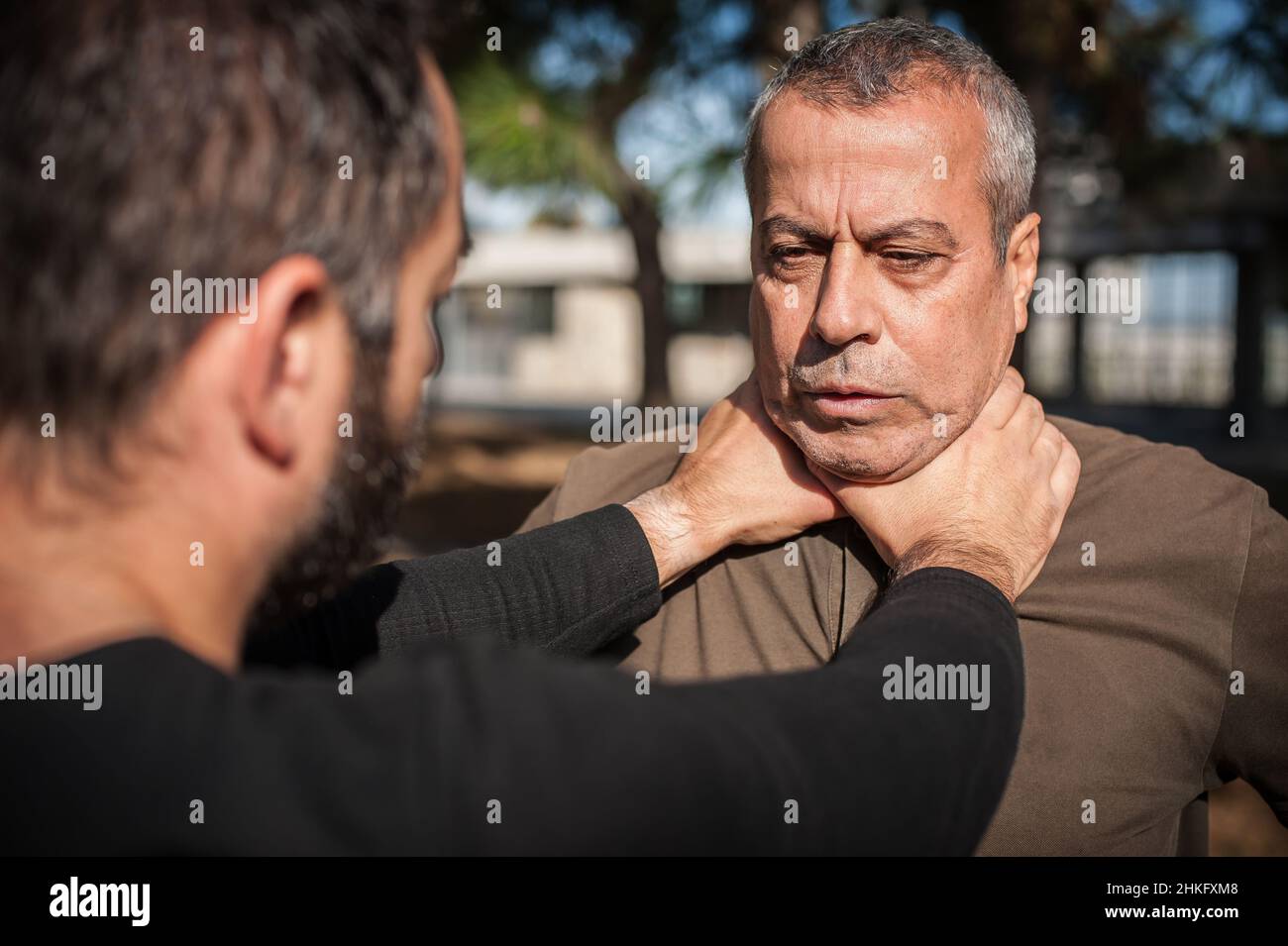 Two men quarrel and fight. Two thugs are fighting. Physical confrontation of people outside on the street Stock Photo