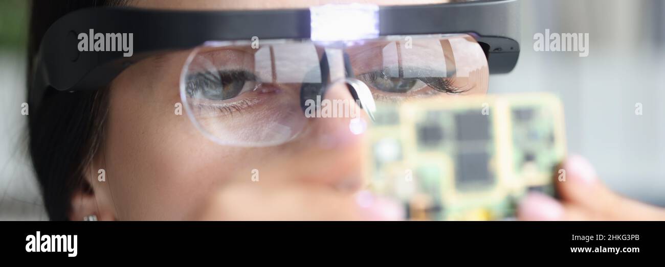Master repairman in goggles looking at computer microchip Stock Photo