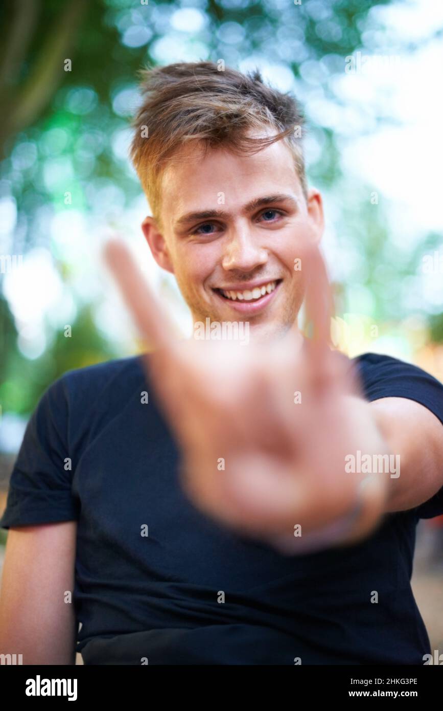 Rock on. A young man showing a rock & roll hand gesture to the camera ...