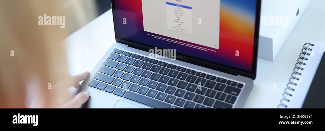 Woman choosing language on new laptop Apple MacBook air closeup Stock Photo