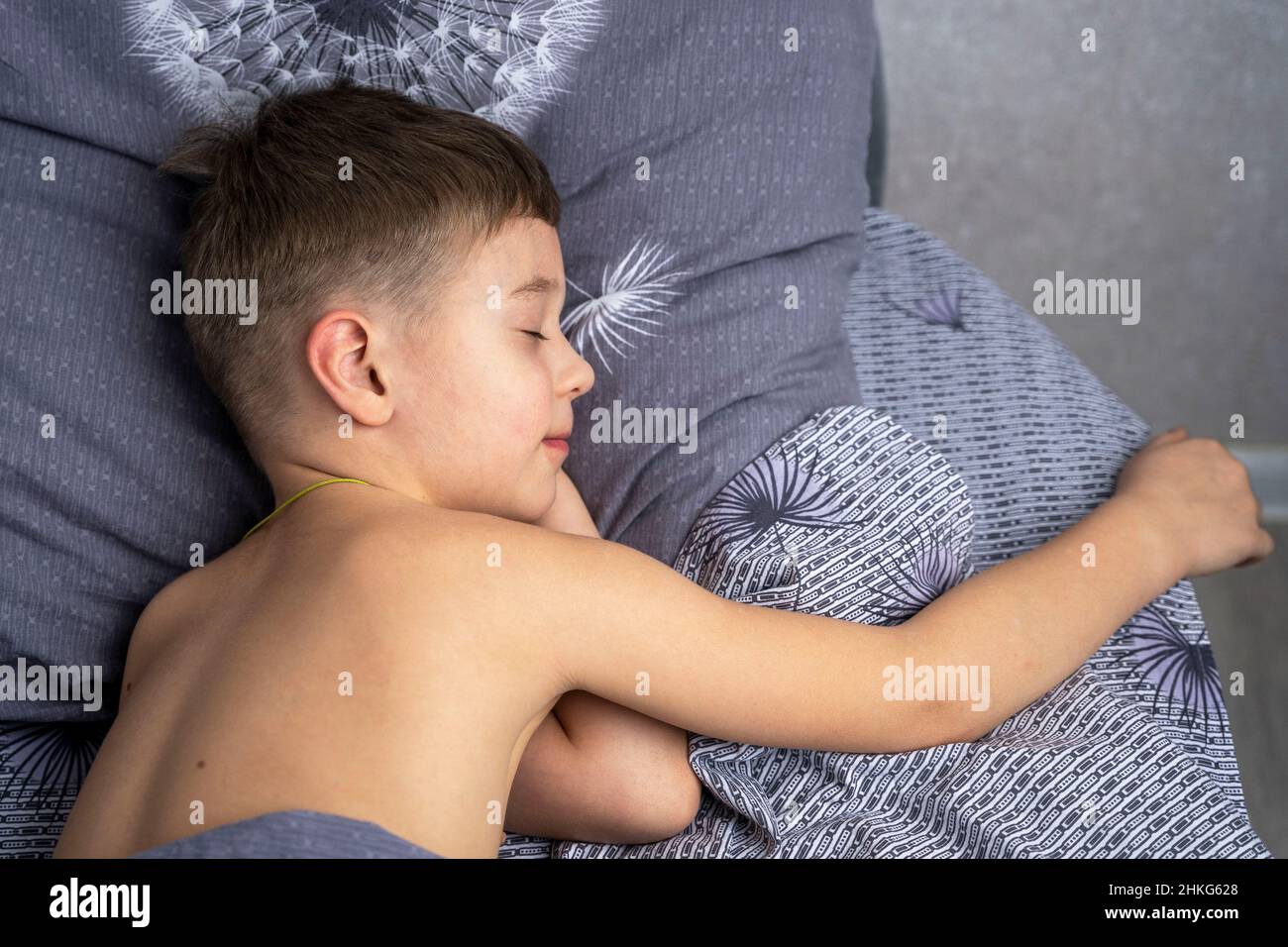 A cute Caucasian boy of 5 years old is sleeping in bed. rest, home comfort and tranquility. Stock Photo