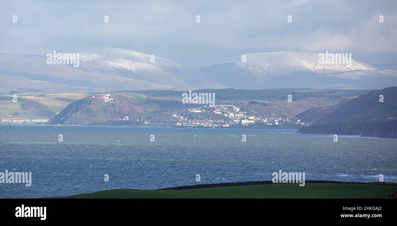 Llanon, Ceredigion, Wales, UK. 04th February 2022 UK Weather: Cold windy day in llanon, mid Wales. With a view across cardigan bay looking towards the seaside town of Aberystwyth and the snow topped mountains of snowdonia in the far distance. © Ian Jones/Alamy Live News Stock Photo