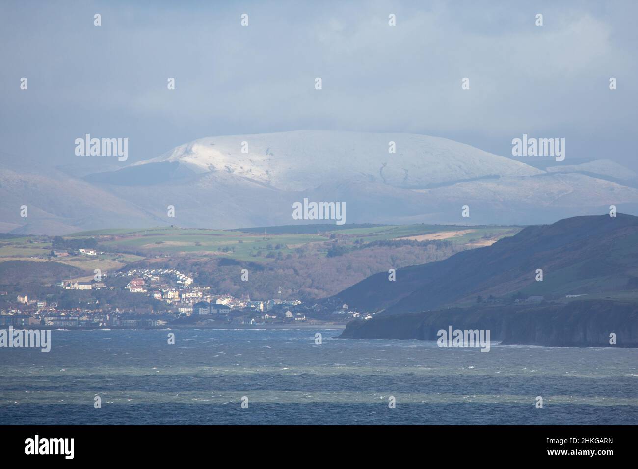 Llanon, Ceredigion, Wales, UK. 04th February 2022 UK Weather: Cold windy day in llanon, mid Wales. With a view across cardigan bay looking towards the seaside town of Aberystwyth and the snow topped mountains of snowdonia in the far distance. © Ian Jones/Alamy Live News Stock Photo
