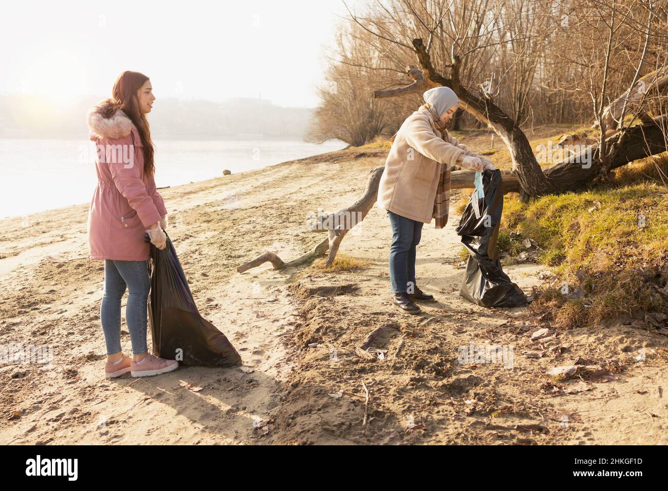 Two volunteers cleaning up the trash from a riverside Stock Photo Alamy