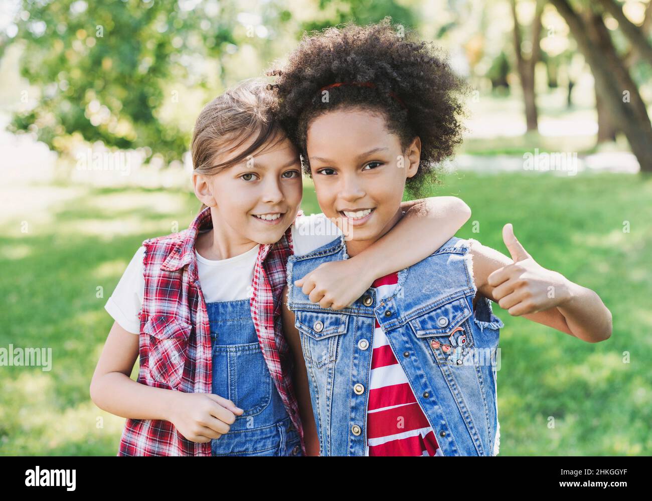 Two little girls hugging in the park. Kids friends playing together outdoor. Summer fun, vacations concept Stock Photo