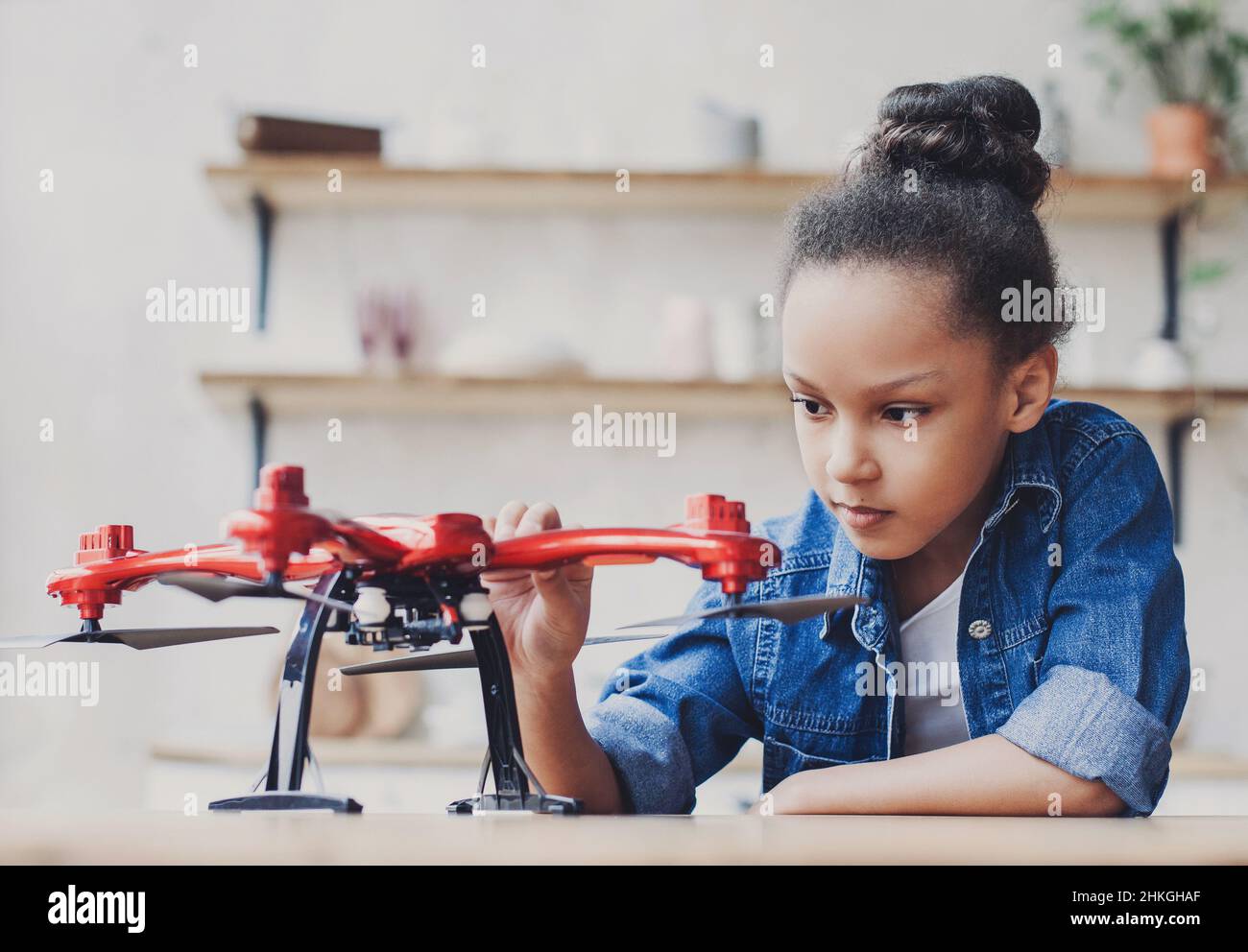 Young cute girl holding quadcopter. Child playing with drone at home. Education, home studying, children, technology, science, future, people concept Stock Photo