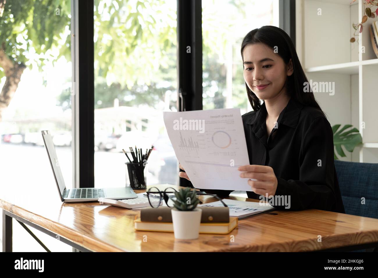 Happy asian businesswoman working with paperwork data chart documents and laptop computer, business financial concept Stock Photo