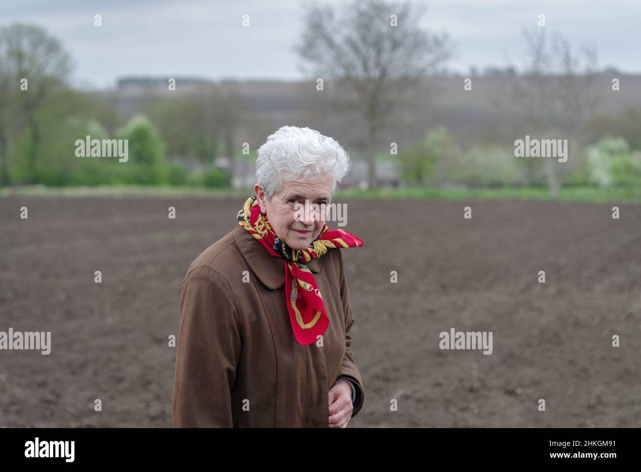 Senior woman standing outdoor in rural setting Stock Photo