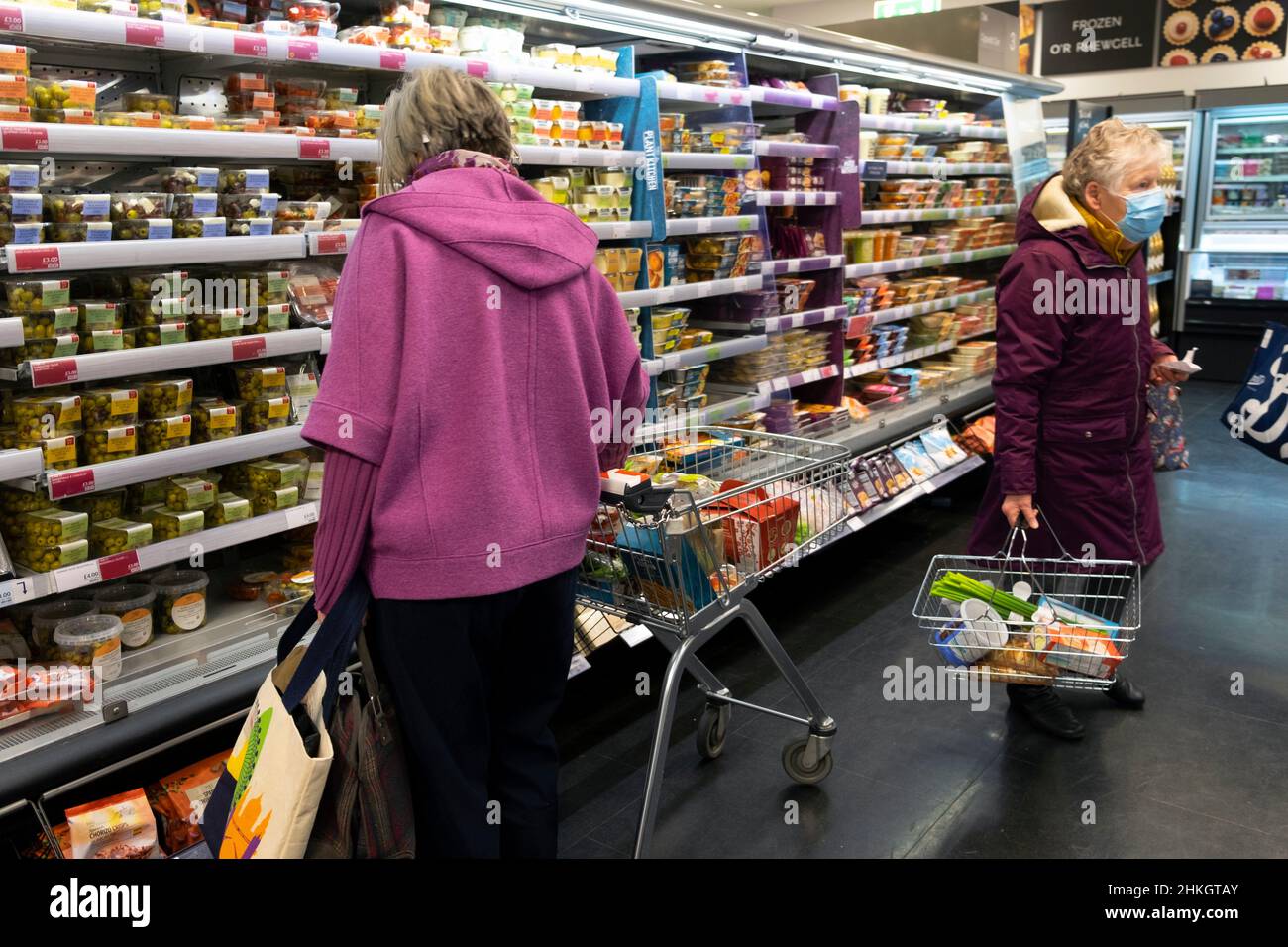 Marks and Spencer store interior inside women shoppers food shopping looking at refrigerated foods on shelf covid mask in 2022 Wales UK KATHY DEWITT Stock Photo
