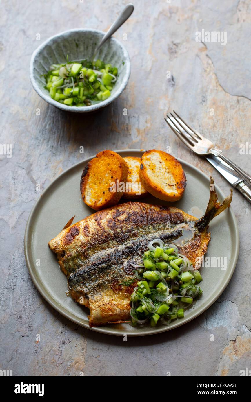 Butterflied mackerel fried with spicy butter with cucumber salsa Stock