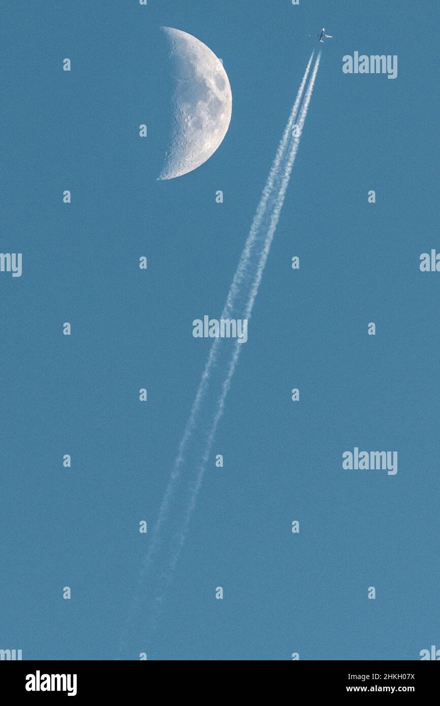 Plane passing near the moon Stock Photo