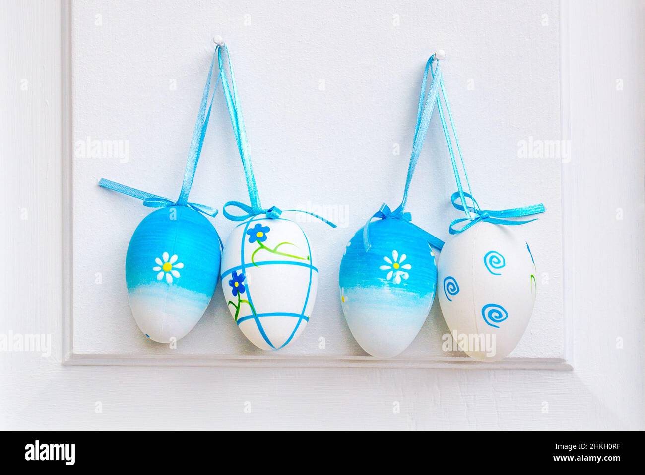 Easter eggs hanging on a white door Stock Photo Alamy