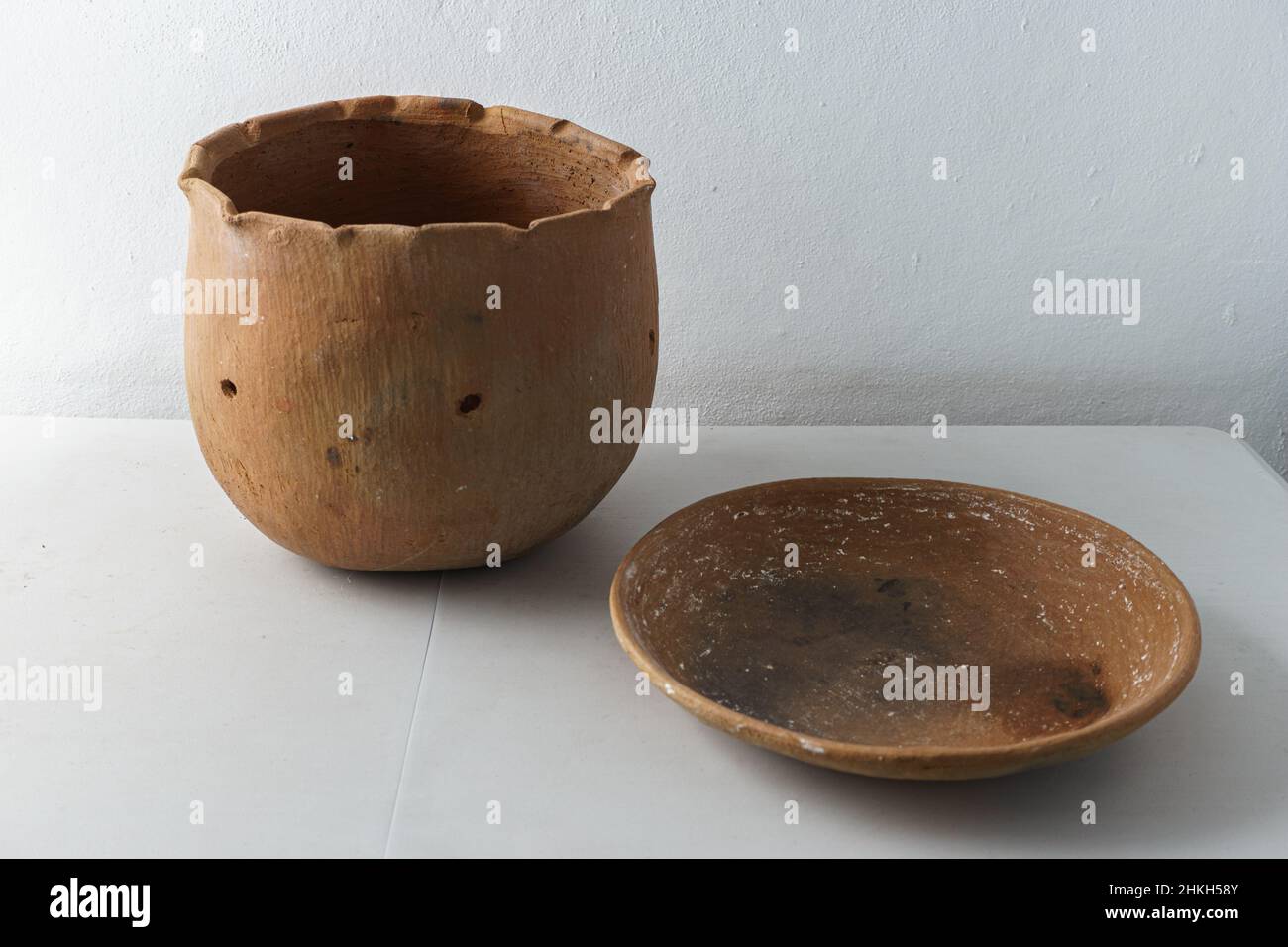 https://c8.alamy.com/comp/2HKH58Y/nicaraguan-terracotta-ware-called-barro-sit-on-a-white-table-these-are-a-comal-for-cooking-tortillas-and-roasting-seeds-and-a-garden-pot-2HKH58Y.jpg