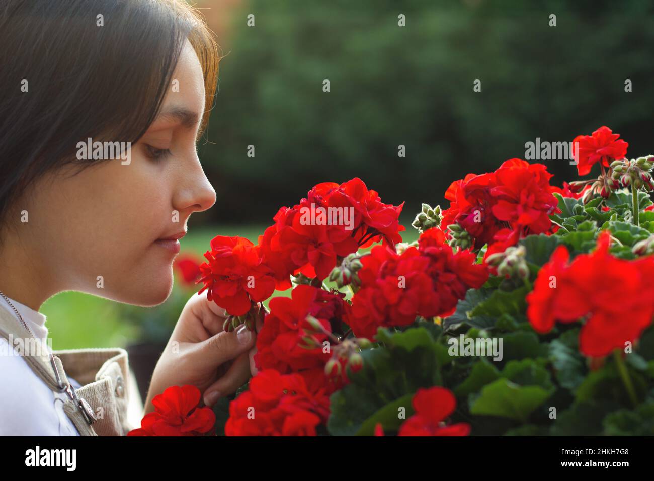 Young girl in the garden of home smelling flower Stock Photo - Alamy