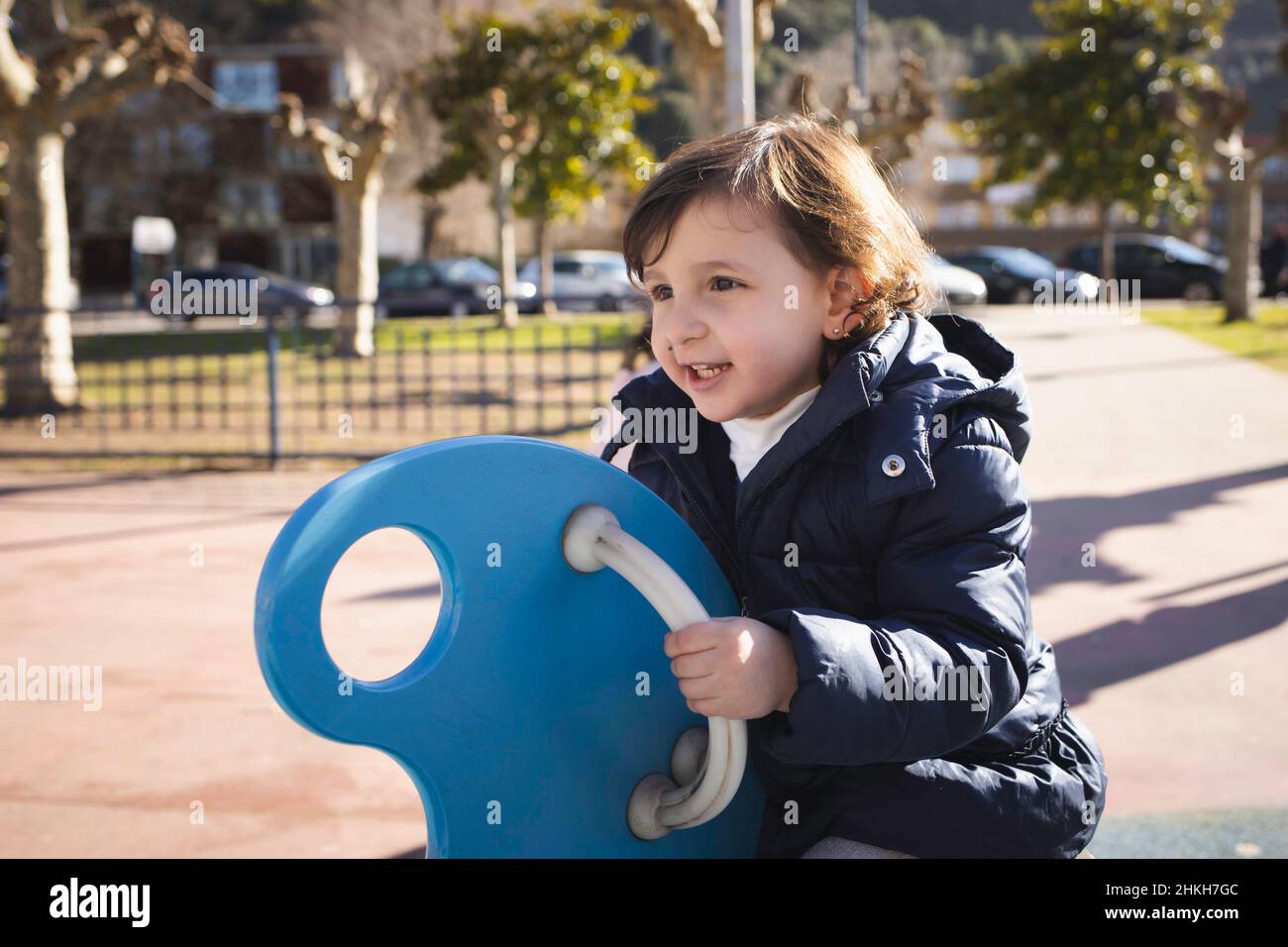 Little girl smiling while playing in the park Stock Photo - Alamy