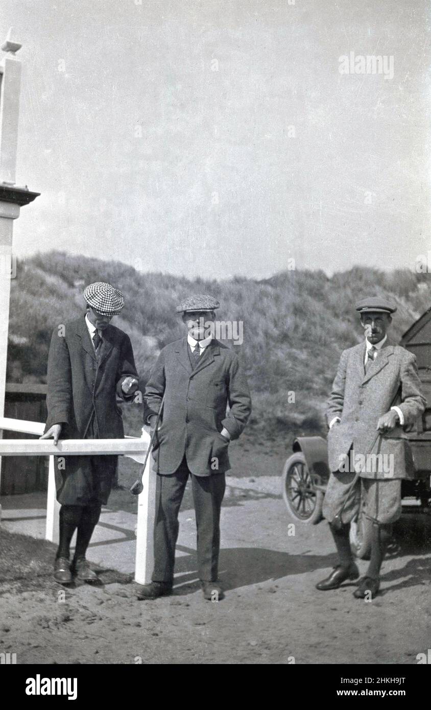 circa 1910, historical, three male golfers in the stylish golfing attire of the era - two in plus twos - standing outside at a links golf course, all wearing cloth caps. The man in the middle, is his distinctive jacket, is J H Taylor, a famous English professional golfer of this era, from 1894 to 1913 the winner of five British Open Championships and one of the pioneer's of the modern game. In 1901 he was a co-founder of the British Professional Golfer's Association. Stock Photo