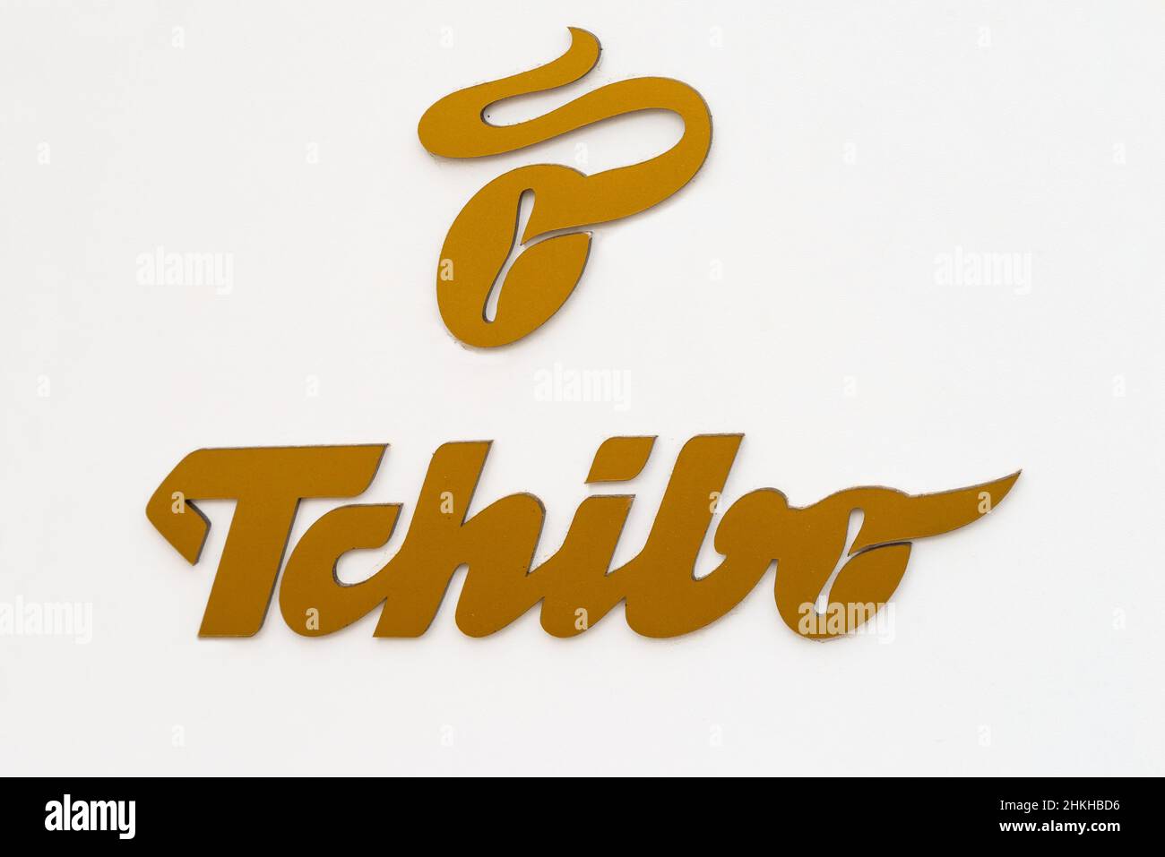 Austria, 2022: Golden Tchibo Logo on white house facade. Tchibo is a German chain of coffee retailers and cafes Stock Photo