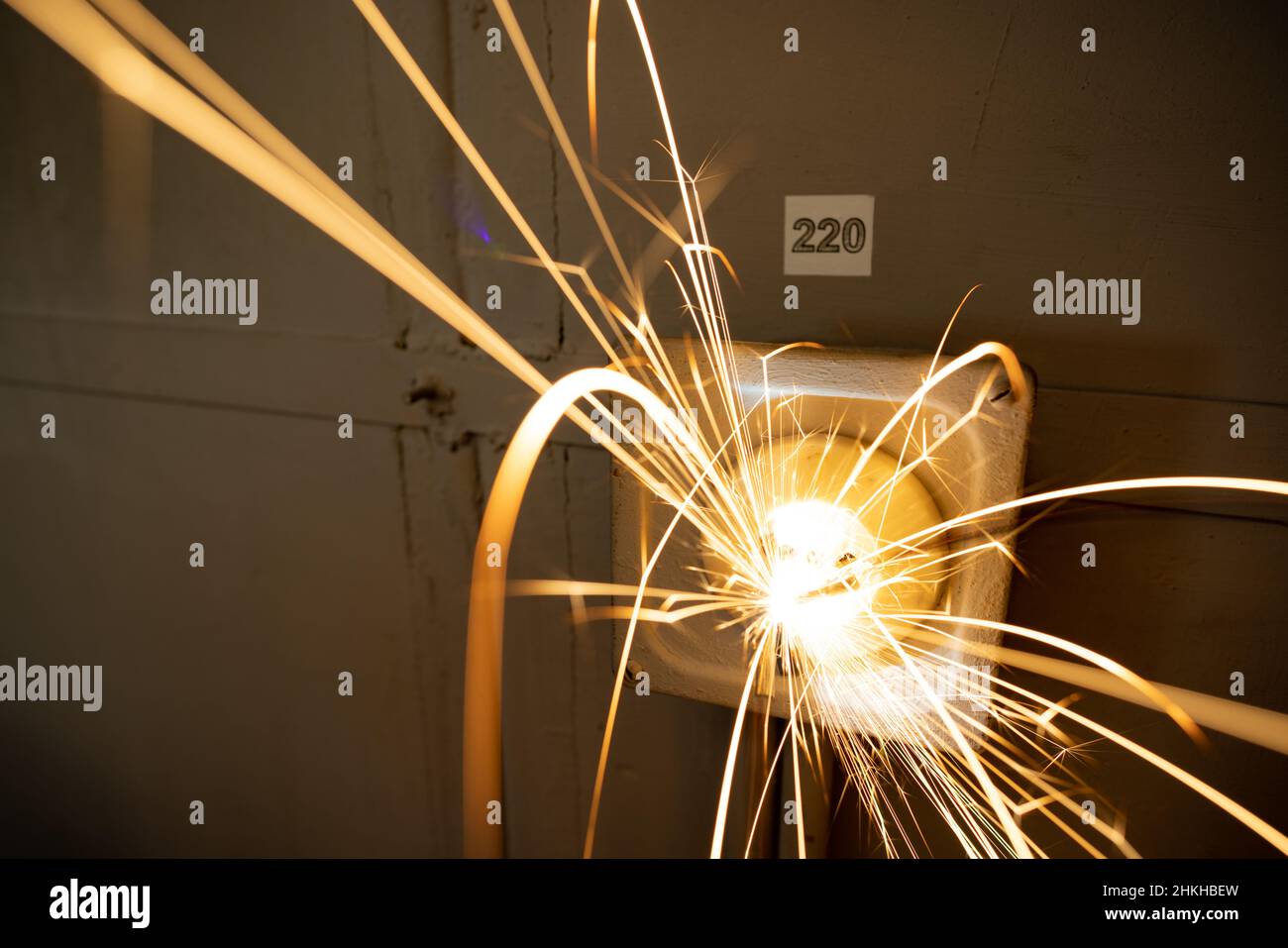 An old faulty outlet with a broken 220 volt power cord plugged in