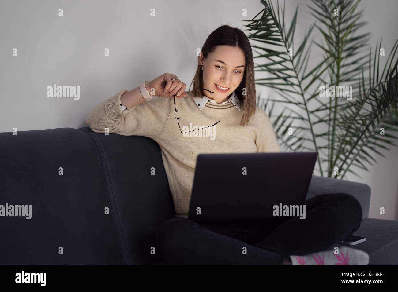Caucasian Woman using laptop while sitting on the sofa at home in the ...