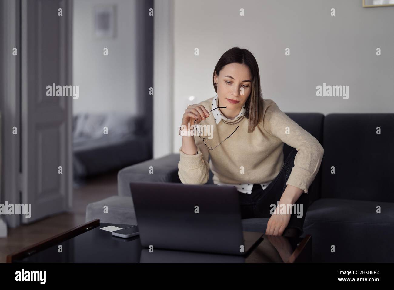 Caucasian Woman using laptop while sitting on the sofa at home in the ...