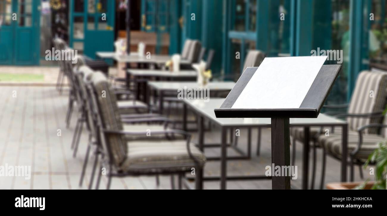 blank food menu on wood podiuem front of outdoor restaurant for adverting to customer Stock Photo