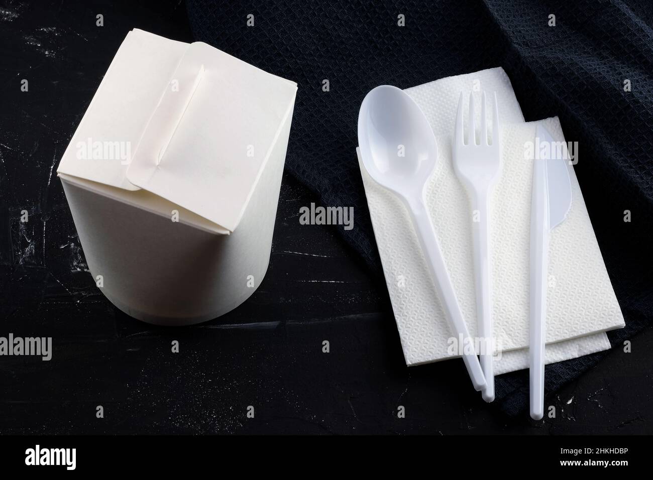 Cardboard food packaging and plastic spoon, knife and fork on a black  background. Takeaway box and disposable cutlery. Paper container for  noodles. Lu Stock Photo - Alamy