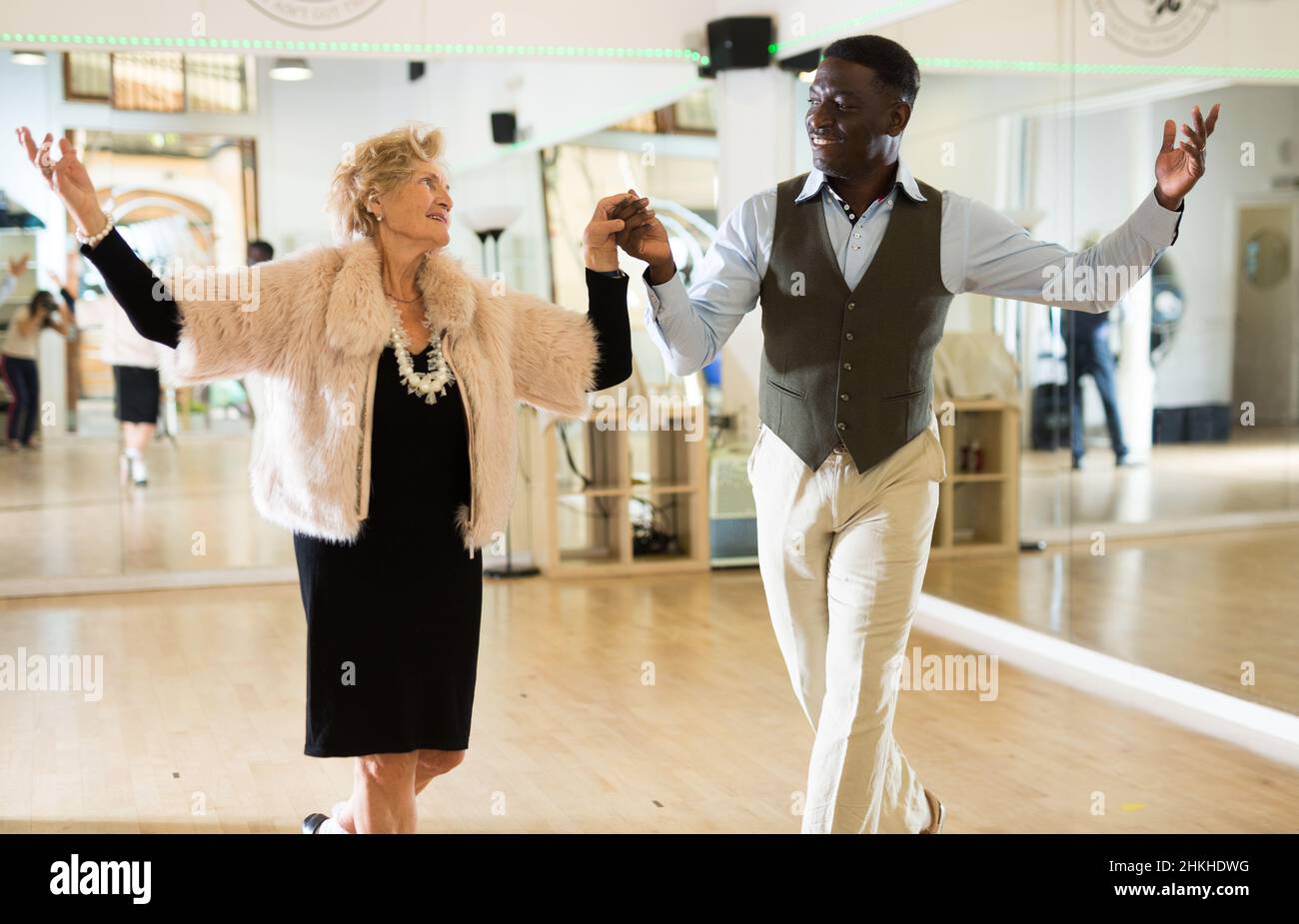 Elderly woman learning ballroom dancing in pair in dance studio Stock ...