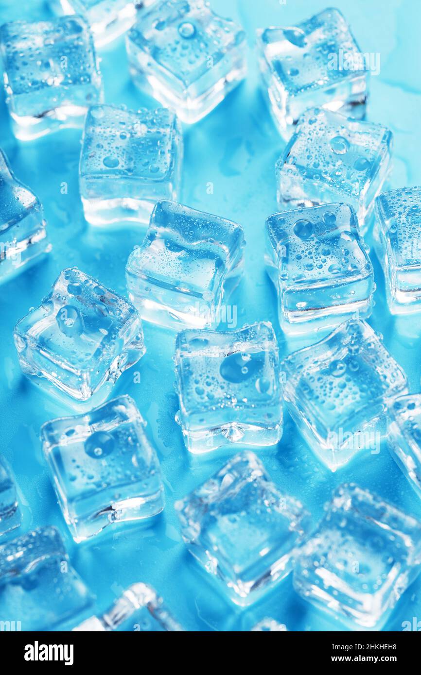 Lots of ice cubes with water drops scattered on a blue background top view  Stock Photo - Alamy