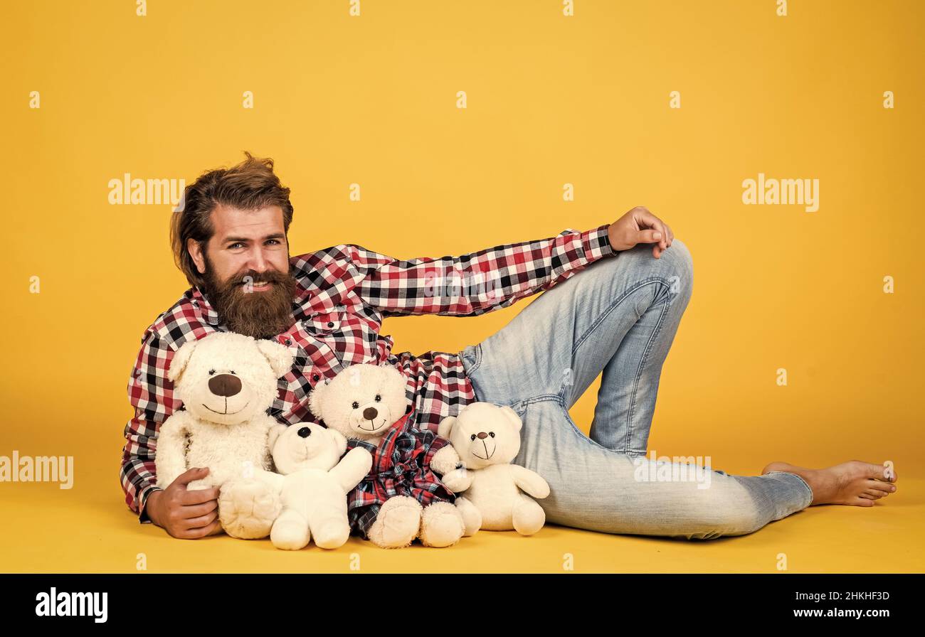 toy shop sales. Holiday celebration concept. Guy with happy face plays with soft toy. Childish mood concept. guy enjoy valentines day. best present Stock Photo