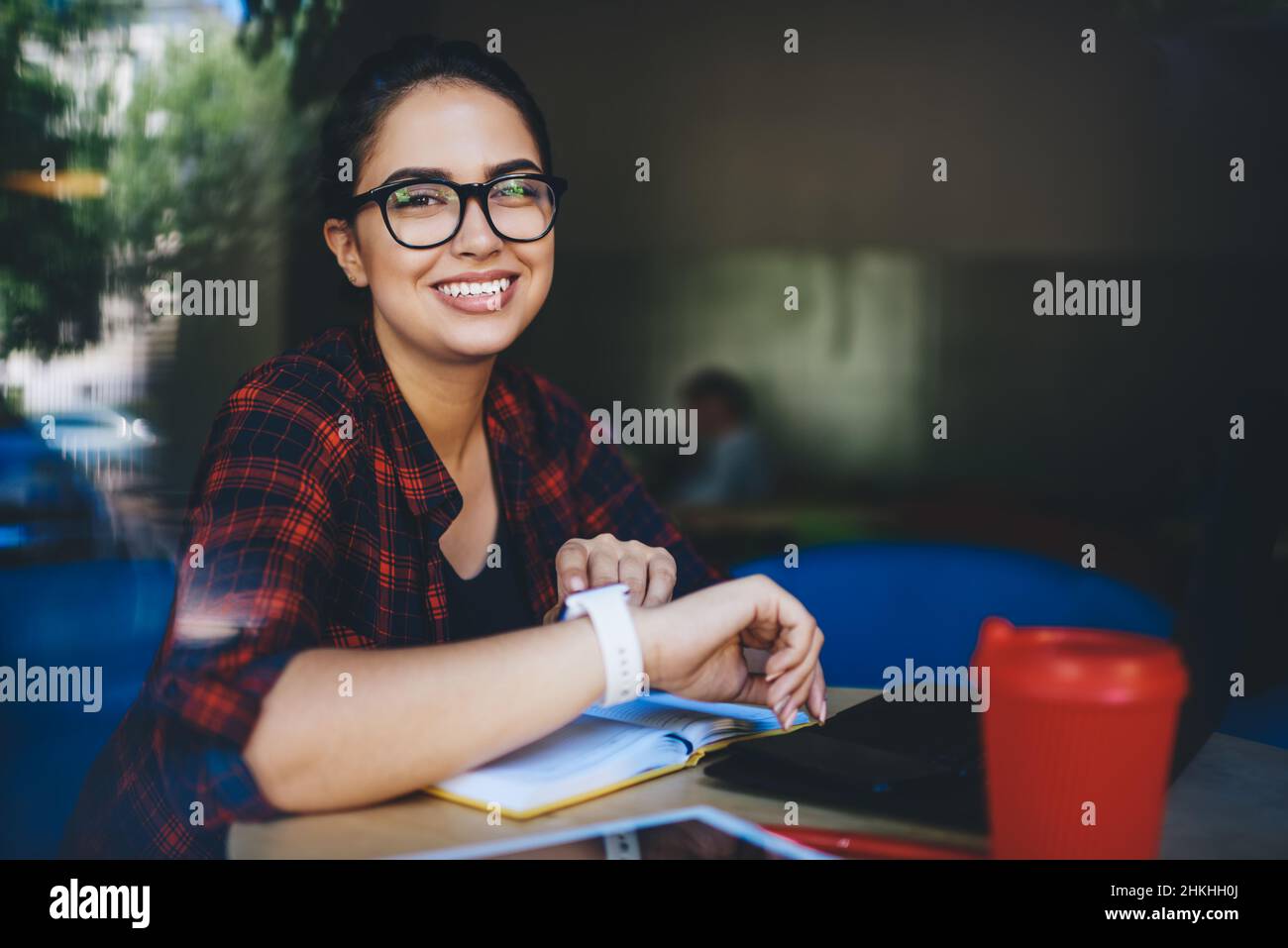 Happy woman sitting in cafeteria Stock Photo