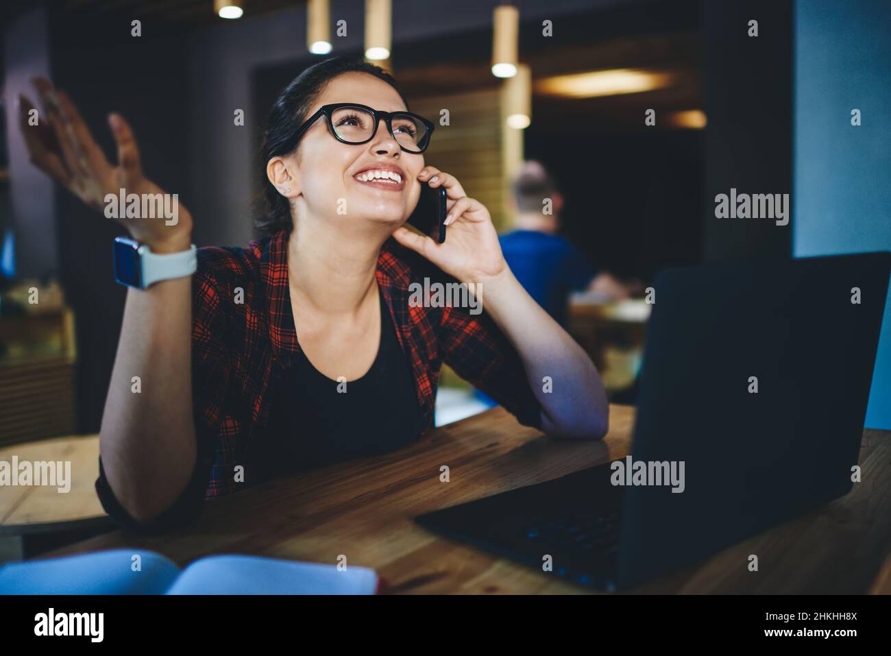 Joyful freelancer talking on phone in cafe Stock Photo