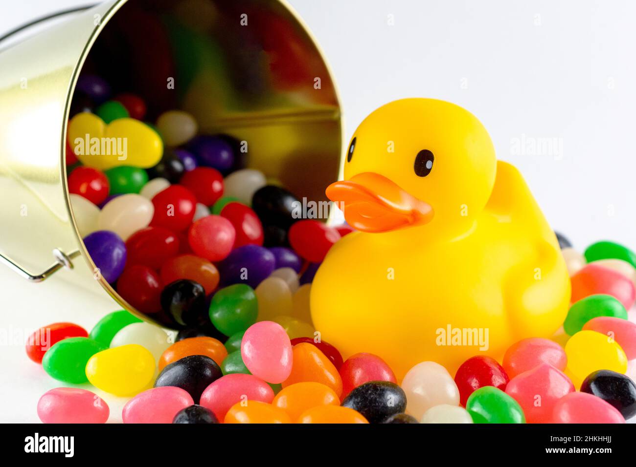 An rubber duck surrounded by assorted jelly beans from spilled pail