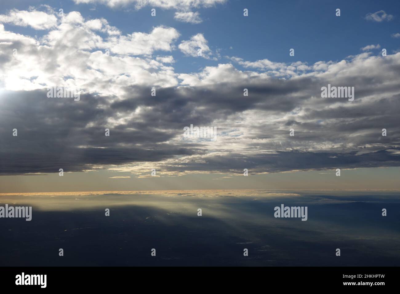 Bright blue sky with white clouds hiding the sun Stock Photo
