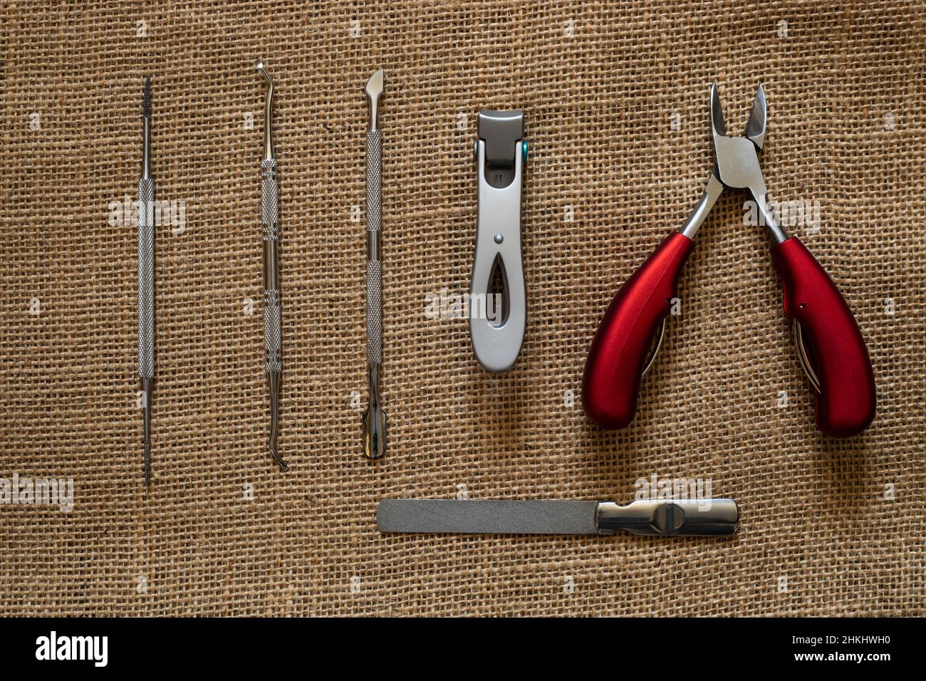 nail care utensils on a burlap background lay flat from above Stock